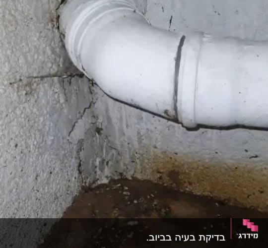 צינור לבן עם נזילה על קיר רטוב